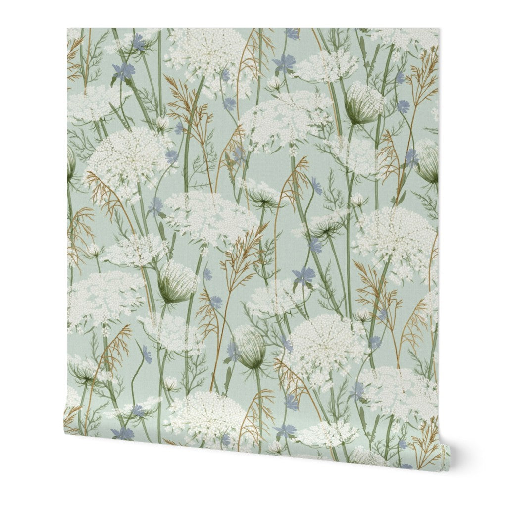 A square sheet of wallpaper featuring a delicate botanical pattern of white wildflowers, green stems, and small blue blossoms on a pale sage green background.