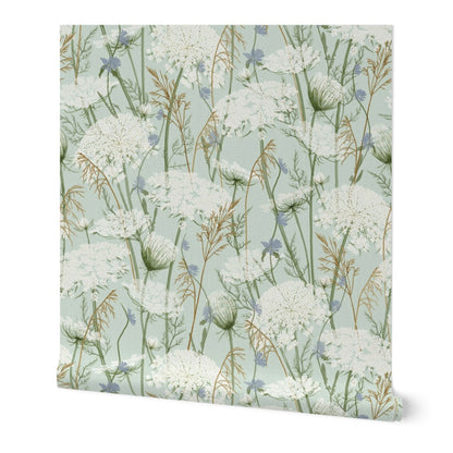 A square sheet of wallpaper featuring a delicate botanical pattern of white wildflowers, green stems, and small blue blossoms on a pale sage green background.